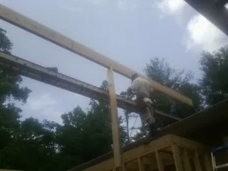 Carpenter setting a ridge beam over a new addition frame — Ice Dam Removal by Roofing Brothers in Royal Center