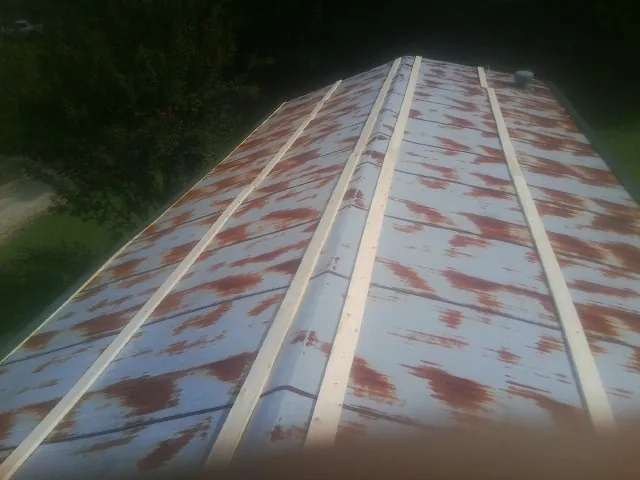 Rusted metal roof panels with new wood purlins before replacement — Storm Damage Roof Repair in Royal Center by Roofing Brothers