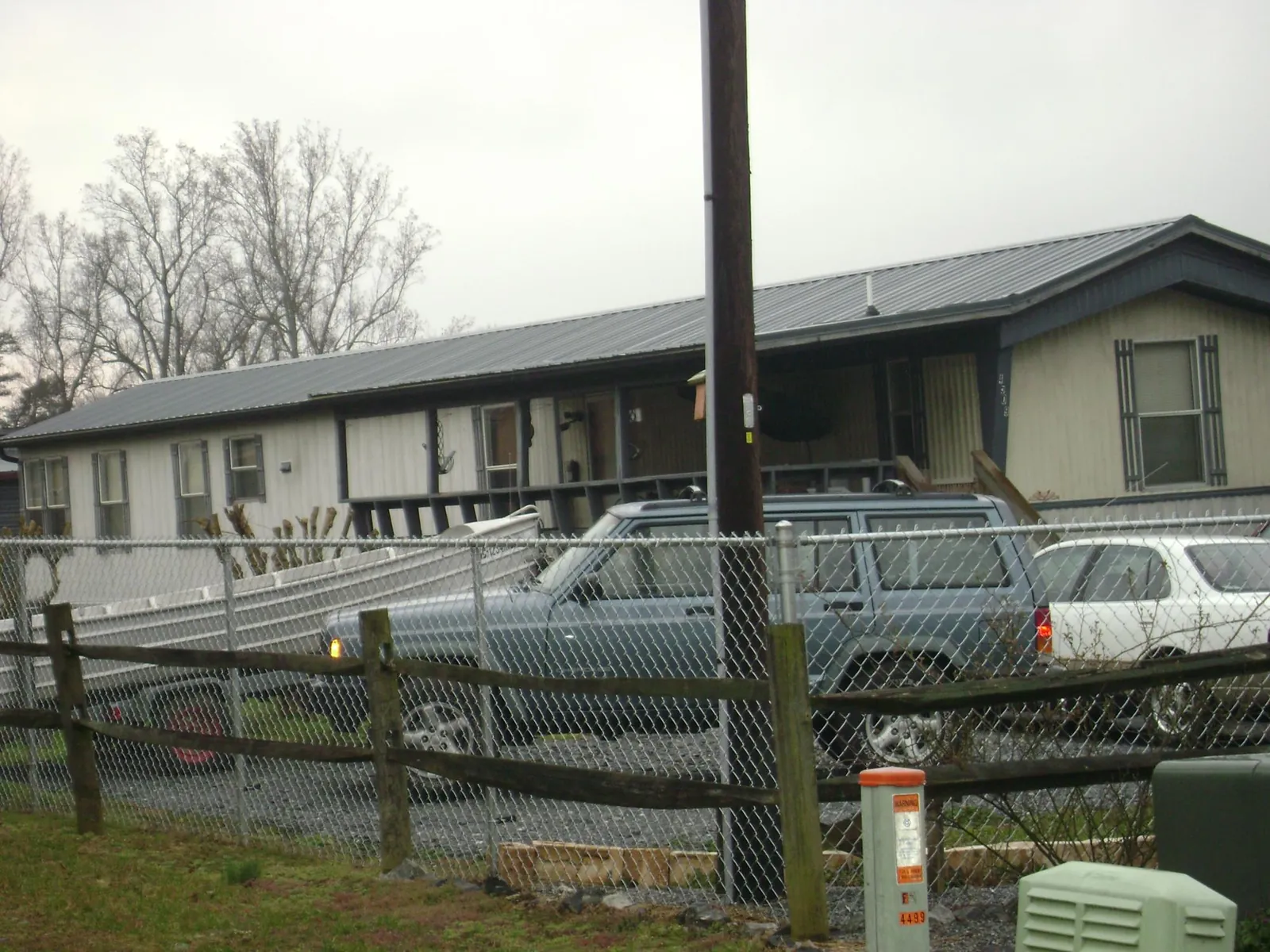 Dark metal roof on a long single story building behind a chain link fence in Royal Center
